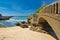 Close up of scenic stone footbridge on sandy beach in scenic seascape of atlantic ocean with waves in blue sky, biarritz, basque c