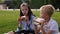 Close-up of a school children eating sandwiches in the park on the green grass.