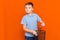 Close up schoolboy in a blue t-shirt throws glasses in the bin on a orange background