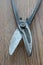 Close-up of scissors for cutting metal parts on a wooden surface. Home craftsman`s tool. Selective focus