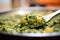 close-up of scooping saag aloo with a spatula