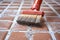 close-up of a scrub brush cleaning grout