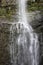 Close up of a section of Wailua Falls tumbling over a volcanic rock cliffside in Hana, Maui, Hawaii