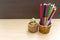 Close up seedling plant of Orange Jessamine  in pot with pencil on wooden background