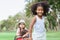 Close up, selective focus on African black afro little girl smiling with happiness, playing with caucasian mixed race girls in