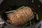 Close up, selective focus on a juicy, pork chashu roast cooking in a large pot filled with soy sauce and green onions