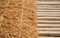 Close up and selective focus shot with copy space of straw stack packed on dried bamboo floor which is decorated in rural farming