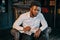 Close up self portrait of stylish, black, afroamerican attractive man in white shirt sitting in work place