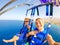 Close up and selfie of two happy people together flying with a kite in the middle of the sea having fun - couple of adults