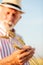 Close up of a senior agronomist or farmer holding and examining wheat stems