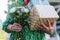 Close up of senior birthday woman holding gifts and bouquet in hands. Garden birthday party for the senior lady.