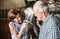 A close-up of senior couple petting a horse in a stable.