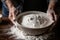 Close up of senior mans hands kneading dough in a bowl, preparing homemade bread