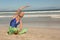 Close up of senior woman practising yoga while sitting on sand