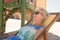 Close up of senior woman with sunglasses resting on chair