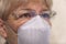 Close up senior woman wearing glasses and face mask during corona virus and flu outbreak.