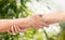 Close up of senior and young woman holding hands