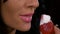 Close-up of sensual young woman eating a strawberry with whipped cream topping in slow motion