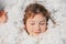 Close up serene cheerful calm, smiling girl face with close eyes in white soft cotton feather. Sleeping well, deep sleep