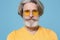 Close up of serious elderly gray-haired mustache bearded man in casual yellow t-shirt, eyeglasses posing isolated on