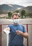 Close up serious Man Wearing blue Medical Mask giving pointing gesture looking at camera. Many countries recommend