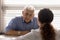 Close up serious old man listening to doctor at meeting