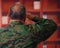 Close up of a serious veteran soldier wearing a military uniform, doing a sign of greetings to the authority with his