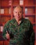 Close up of a serious veteran soldier wearing a military uniform, with thumps up in a blurred background