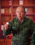 Close up of a serious veteran soldier wearing a military uniform, using a stethoscope, in a blurred background