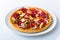 Close up of served pizza with salami, chicken, mushroom, paprika, cheese on a plate isolated on white background