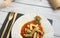 Close up of served table with plate of pasta with tomato sauce and dried flowers