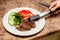 Close-up serving homemade grilled beef medallions with grilled pepper, fresh cucumber and parsley on a round white plate. Concept