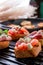 Close up of set bruschetta on black grill background. Tasty antipasto.