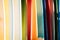 Close up Set of different color surf boards in a stack on sandy beach for rent. Multicolored surfboards as rainbow.