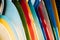 Close up Set of different color surf boards in a stack on sandy beach for rent. Multicolored surfboards as rainbow