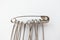 Close-up set of metall safety pins for crafts, fashion, jewelry, hobby or household on white background. Isolated object,