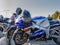 Close-up of several motorcycles are parked on a city street.