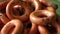 Close-up, sewing pastries rotates. Crispy toasted bagels with poppy seeds falling and spinning on a light surface shallow depth of