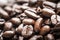 Close-up, shallow focus of dark roasted coffee beans seen ready to be ground up, to produce fresh coffee.