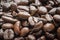 Close-up, shallow focus of dark roasted coffee beans seen ready to be ground up, to produce fresh coffee.