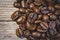 Close-up, shallow focus of dark roasted coffee beans seen ready to be ground up, to produce fresh coffee.