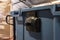 Close-up, shallow focus view of a large blue recycle bin and fork pump truck seen at a warehouse centre.