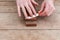 Close up of sharpening the knife with a whetstone on a wooden background. Top view