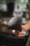 A close-up of a shaving accessory on a blurred background. A black brush in white talcum powder. Tools for cutting beard