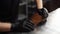 Close-up of shoemaker inserts wooden shoe block into worn light brown leather shoes to be repaired