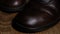 Close-up A shoemaker restores leather men`s shoes, applies brown cream to old worn-out shoes, a shoemaker wipes shoes