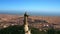 Close-up shooting from a drone on the sculpture of Jesus on mount Tibidabo and a view of Barcelona, the Mediterranean sea and