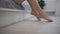 close-up shooting. legs of a female getting out of bed. light background, morning wakes up. white bed female toes. go on