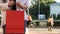 Close-up of a shopaholic woman with a red paper shopping bag in her hands. Crop the photo. Consumerism, shopping, lifestyle