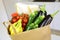 Close up shopping bag full of fresh food on kitchen desk. Home delivery food groceries paper bag